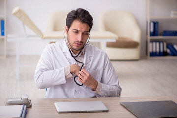 Fototapeta premium Young male doctor working in the clinic