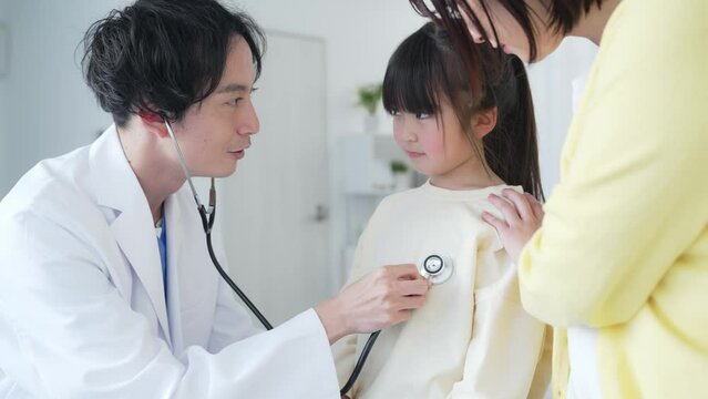 入院している女の子を診察する医師　小児科医