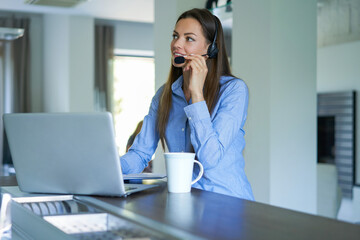 Freelance operator talking with headsets and consulting clients from home office.