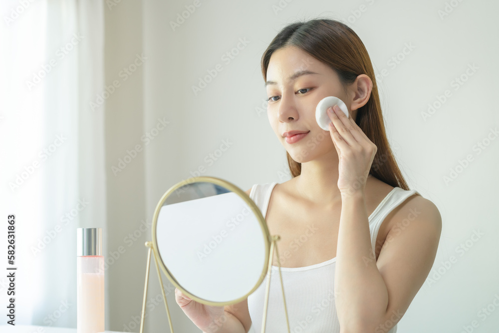 Wall mural happy beauty, attractive asian young woman, girl looking reflect in mirror, hand holding cotton pad,