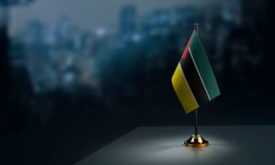 Small flags of the Mozambique on an abstract blurry background