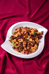 wok fried chicken cube meat with spicy hot dry chilli in Szechuan style on red white cloth asian chinese banquet halal menu