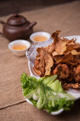 deep fried crispy golden chicken meat with ginger slices and garlic on wood table chinese tea pot asian halal banquet menu