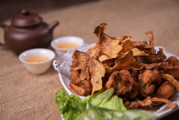 deep fried crispy golden chicken meat with ginger slices and garlic on wood table chinese tea pot asian halal banquet menu