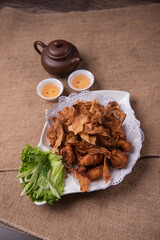 deep fried crispy golden chicken meat with ginger slices and garlic on wood table chinese tea pot asian halal banquet menu