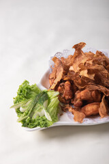 deep fried crispy golden chicken meat with ginger slices and garlic on wood table chinese tea pot asian halal banquet menu