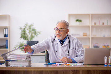 Old male doctor pharmacist in drugs synthesis concept