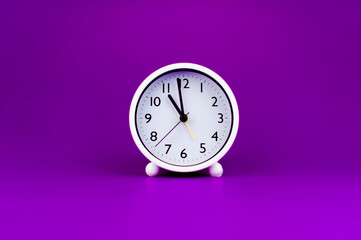 White clock on purple background, time concept Time planning
