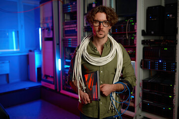 Portrait of signalman with many wires on shoulders and laptop in hand