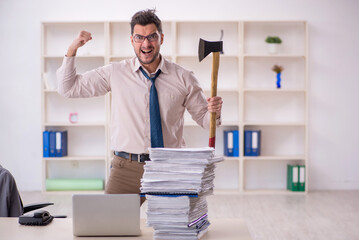 Young male employee unhappy with excessive work in the office