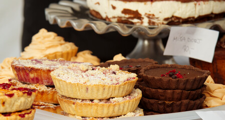 Forest fruit tarts, chocolate tarts with salt caramel and lemon tarts on display at the pastry stand at the farmers street food market in Prague. No people, no AI.