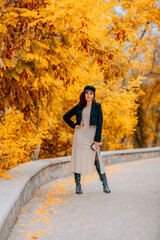 A woman walks outdoors in autumn, enjoys the autumn weather.