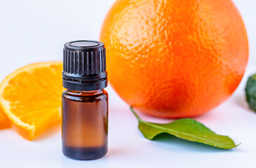 Essential oil of orange. Dark glass bottles with essential oil and orange on white background