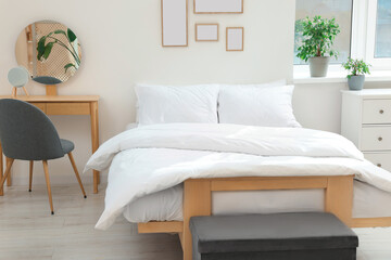 Bed with soft white pillows in cozy room interior