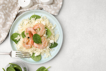 Delicious couscous with shrimps and spinach served on white table, flat lay. Space for text