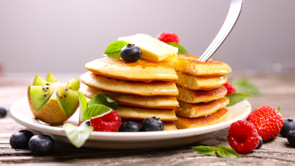 Pancakes with fresh berries fruits, blueberries, strawberries and maple syrup