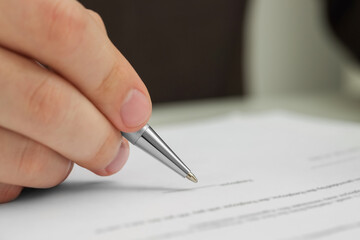 Man signing document, closeup view. Space for text