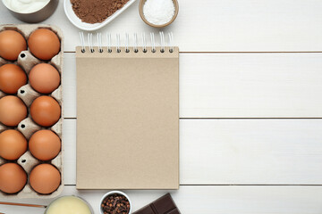 Blank recipe book and different ingredients on white wooden table, flat lay. Space for text