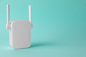 New modern Wi-Fi repeater on turquoise background, space for text