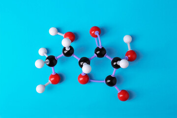 Molecule of vitamin C on light blue background, top view. Chemical model