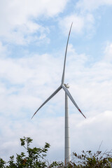 Fototapeta na wymiar Wind generator turbine against blue cloudy sky.