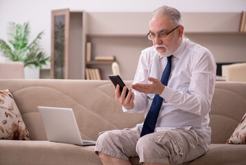 Old male employee working from home during pandemic