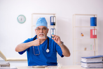 Old male doctor working in the clinic