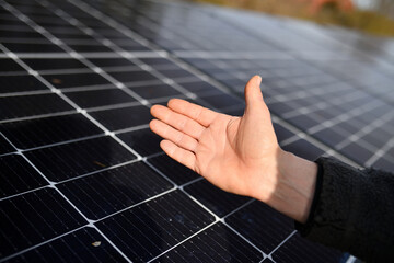 Hand mit Daumen hoch eines Elektrikers zeigt Photovoltaik Solar Module auf einem Haus Dach....