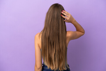 Young Lithuanian woman isolated on purple background in back position and thinking