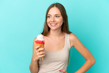 Young Lithuanian woman with cornet ice cream isolated on blue background posing with arms at hip and smiling