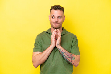 Young caucasian handsome man isolated on yellow background scheming something