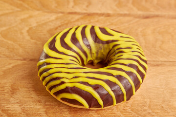 Donuts with sweet filling, covered with chocolate on a wooden background. The concept of baking delicious donuts.