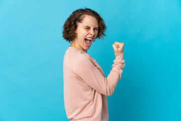 Young English woman isolated on blue background celebrating a victory