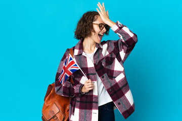 Young English woman holding an United Kingdom flag isolated on blue background has realized something and intending the solution