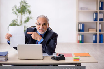 Old male boss working in the office