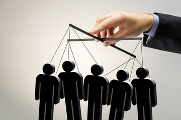 Businessman, male hand, puppeteer controls a group of people.