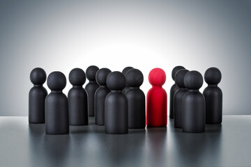 New leader or new employees to team. red wooden figure of people extends its influence to the neighboring figures.