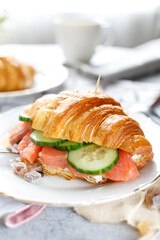 close up croissant with fish on the table in the kitchen light colors