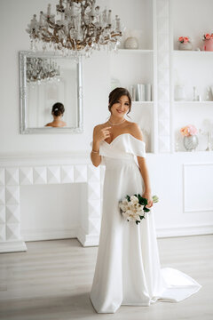 brunette bride in a tight wedding dress in a bright studio