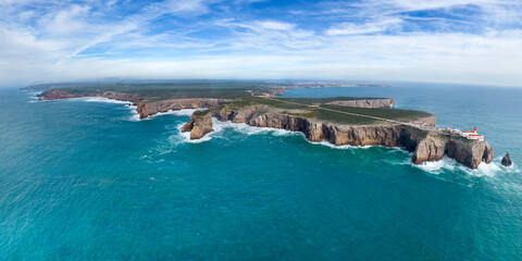 The lighthouse on high cliffs and strong waves hitting the rock at Cape St. Vincent. Continental Europe's most South-western point, Sagres, Algarve, Portugal.	