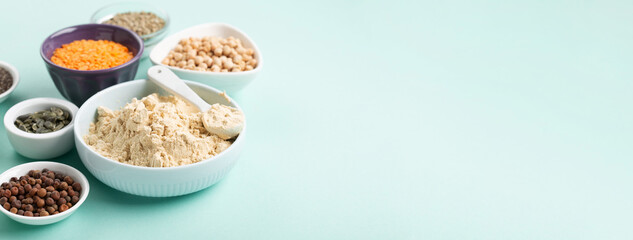 Healthy Dry Pea Protein Powder and Plant Based Protein Food (legumes, lentils, beans, seeds) on Blue Green Background.