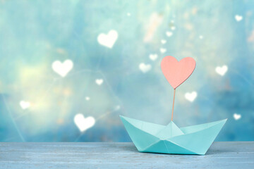 holiday travel concept - paper boat with heart sail