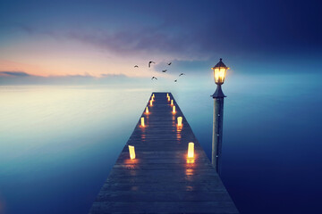 romantic beach with wooden jetty and lamps, romantic travel