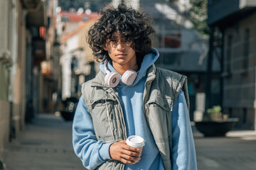 Fototapeta na wymiar young man with headphones and coffee on the street
