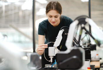 Computer science development engineer working on robotic arm connection at futuristic electronic...