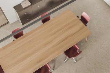 Top view of light conference room interior with table, chairs and drawer