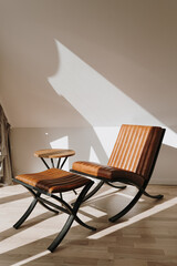 Modern interior decorated with leather lounge armchair. Aesthetic warm sunlight shadows on the...