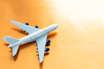 Small white airplane on orange background.