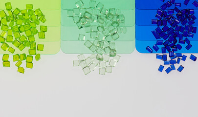 colored transparent plastic resin granulates with color sample plates in laboratory
