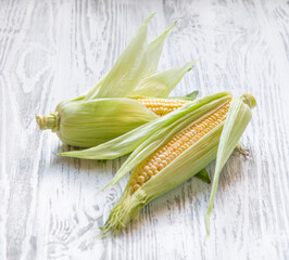 Fresh corn on a white wooden background. Farm healthy and eco-friendly vegetables. Rustic style.